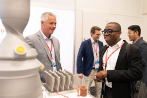 Attendee looking at metal 3D printed parts at HI-AM 2022.